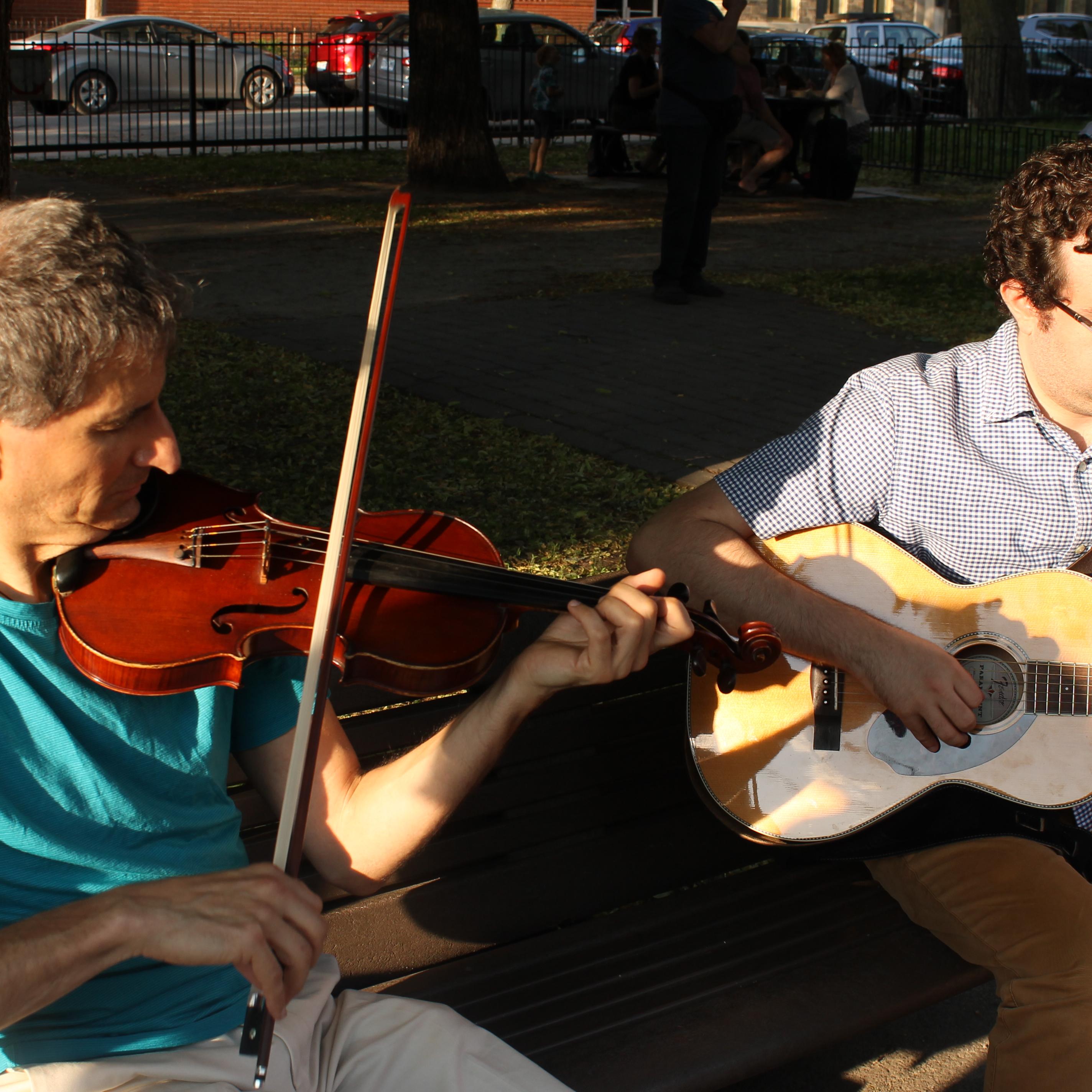 Deux musiciens jouant sur un banc de parc